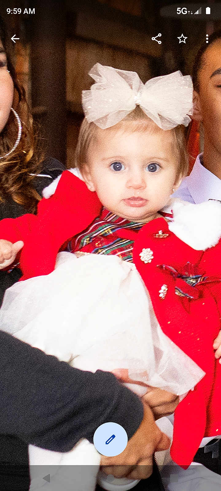 Dalylah is registered to the contest to win money with this photo: baby, blue_eyes, celebration, child, cute, family, fashion, festive_clothing, hands, holding, indoor, people, person, portrait, red_cardigan, smile, toddler, white_bow, white_dress, young_child