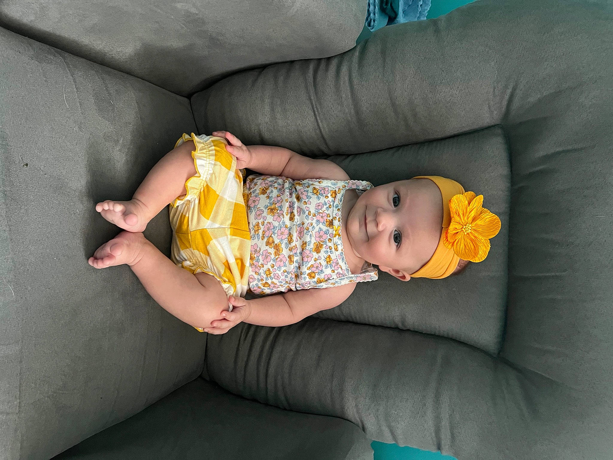 Dorothea is registered to the contest to win money with this photo: baby, baby_products, baby_toddler_clothing, chair, child, comfort, couch, dress, finger, headwear, human_leg, joy, knee, lap, linens, pattern, person, room, sitting, sock