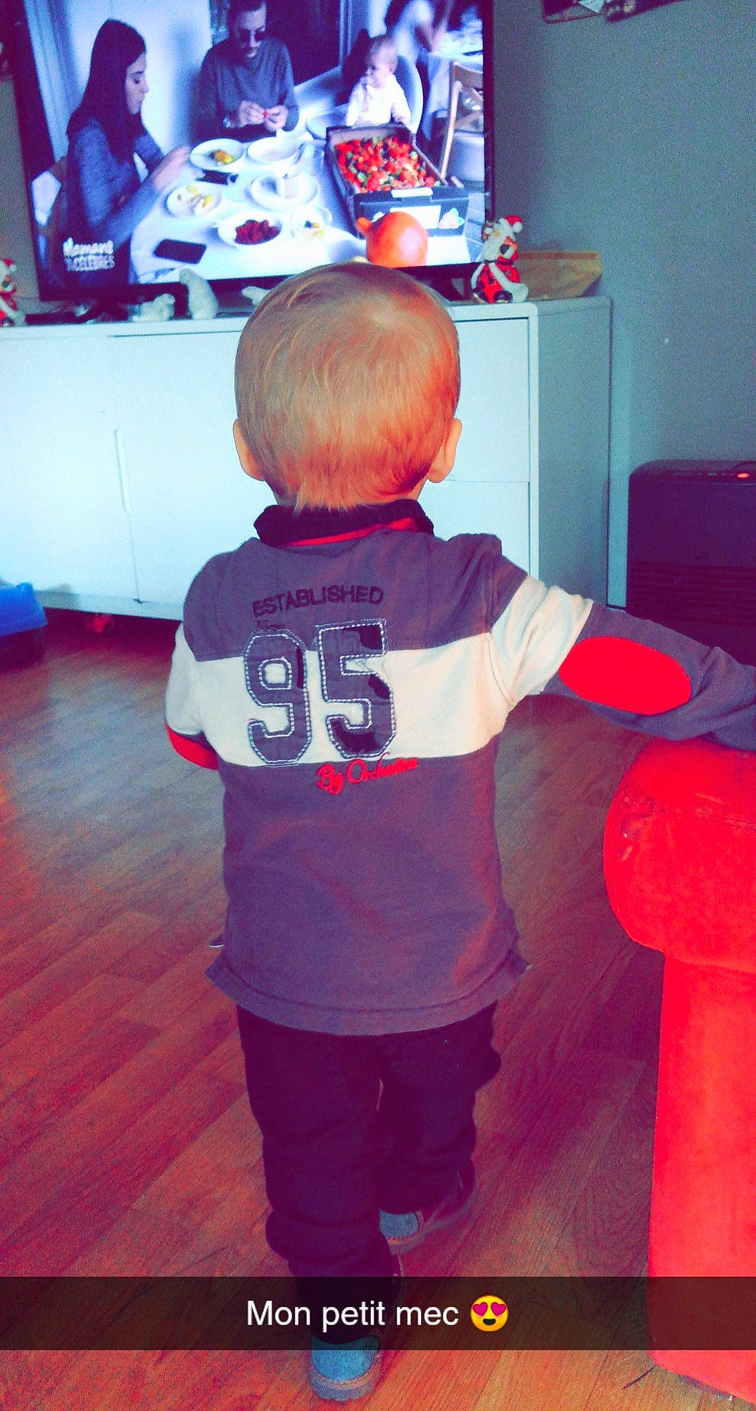 Leandro a rejoint le concours — aidez-le/la à gagner de superbes lots ! baby_toddler_clothing, back, cabinetry, chest_of_drawers, display_device, flat_panel_display, floor, flooring, hip, human_body, laminate_flooring, led_backlit_lcd_display, maroon, person, play, red, room, standing, television, television_set