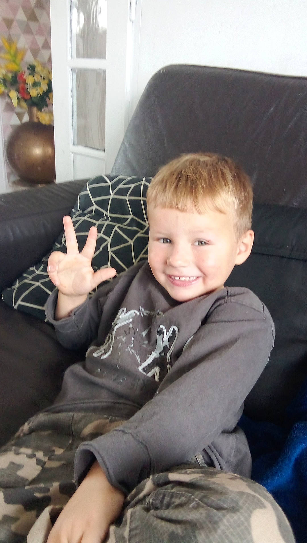 Leandro participe au concours pour gagner de l'argent avec cette photo : child, comfort, couch, face, fun, human_leg, joy, knee, lamp, lap, laugh, living_room, pattern, person, picture_frame, room, sitting, smile, studio_couch, toddler