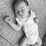 baby, sleeping, infant, onesie, couch, texture, monochrome, black_and_white, peaceful, relaxed, person, newborn, skin, hand, foot, portrait, indoors, closeup, resting, soft_lighting
