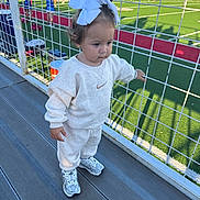 Fallyn joined the competition — help win amazing prizes! bleachers, casual_clothing, child, daylight, football_field, girl, green_field, nike, outdoor, shadows, sneakers, spectators, sports, stadium, sweatpants, sweatshirt, toddler, white_bows, wire_fence, young_child