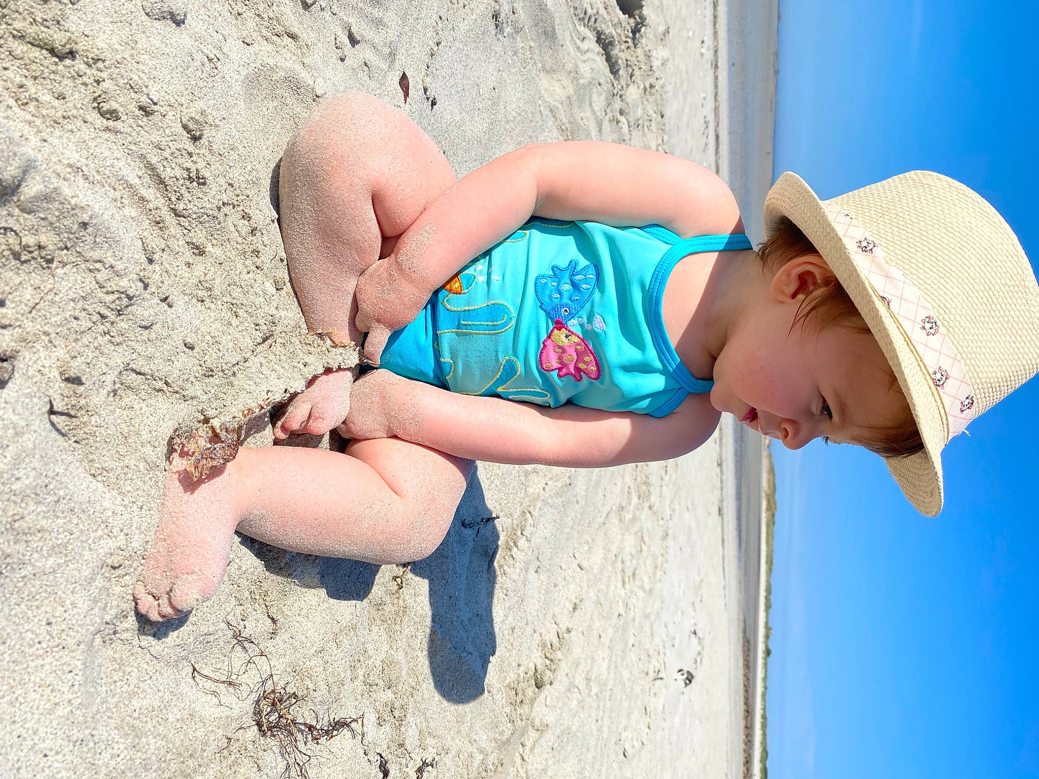 Saphia a rejoint le concours — aidez-le/la à gagner de superbes lots ! beach, blue, body_of_water, cap, clothing, finger, fun, happy, hat, head, headgear, human, leg, leisure, person, shorts, sun_hat, t_shirt, thigh, toddler