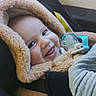 baby, child, car_seat, smile, hooded_coat, fluffy, pacifier, infant, seatbelt, car_interior, happy, young_child, warm_clothing, cute, portrait, safety, infancy, toddler, car_window, cozy