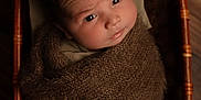 Numa participe au concours pour gagner de l'argent avec cette photo : baby, infant, blanket, wicker_basket, brown, wrapped, portrait, face, eyes, curious, indoors, wood_floor, cozy, soft_texture, newborn, child, person, cute, warm, resting