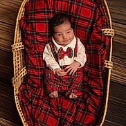Numa participe au concours pour gagner de l'argent avec cette photo : baby, infant, wicker_basket, plaid, red, bow_tie, clothing, blanket, wood_floor, portrait, cute, smiling, person, indoors, fabric, newborn, baby_clothes, baby_boy, resting, cozy