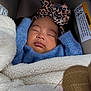 baby, sleeping, car_seat, headband, leopard_print, blue_sweater, blanket, cozy, infant, child, face, peaceful, indoor, closeup, cute, portrait, resting, soft_texture, warm, bundle