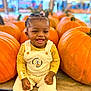 child, toddler, pumpkin, pumpkin_patch, smiling, overalls, winnie_the_pooh, yellow_clothing, happy, sitting, fall, harvest, cute, outdoor, festival, holiday, autumn, baby, portrait, seasonal