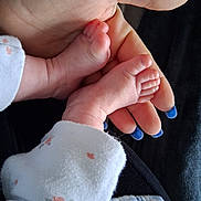 Lottie Button is registered to the contest to win money with this photo: baby_feet, infant, hand, adult_hand, nails, blue_nail_polish, skin, newborn, clothing, fabric, floral_pattern, close_up, gentle, tender, cute, small, soft, human, protection, care