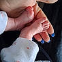 baby_feet, infant, hand, adult_hand, nails, blue_nail_polish, skin, newborn, clothing, fabric, floral_pattern, close_up, gentle, tender, cute, small, soft, human, protection, care