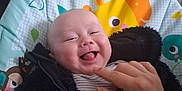 Lottie Button joined the competition — help win amazing prizes! baby, smile, tongue, hand, jacket, baby_seat, animal_print, indoor, happy, person, face, clothing, furniture, cozy, cute, child, playful, human, infant, joy