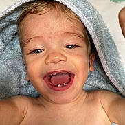 Malo participe au concours pour gagner de l'argent avec cette photo : baby, child, towel, blue, smiling, teeth, happy, face, skin, mouth, eyes, expression, closeup, portrait, infant, cute, bare_shoulders, indoor, light, soft_texture