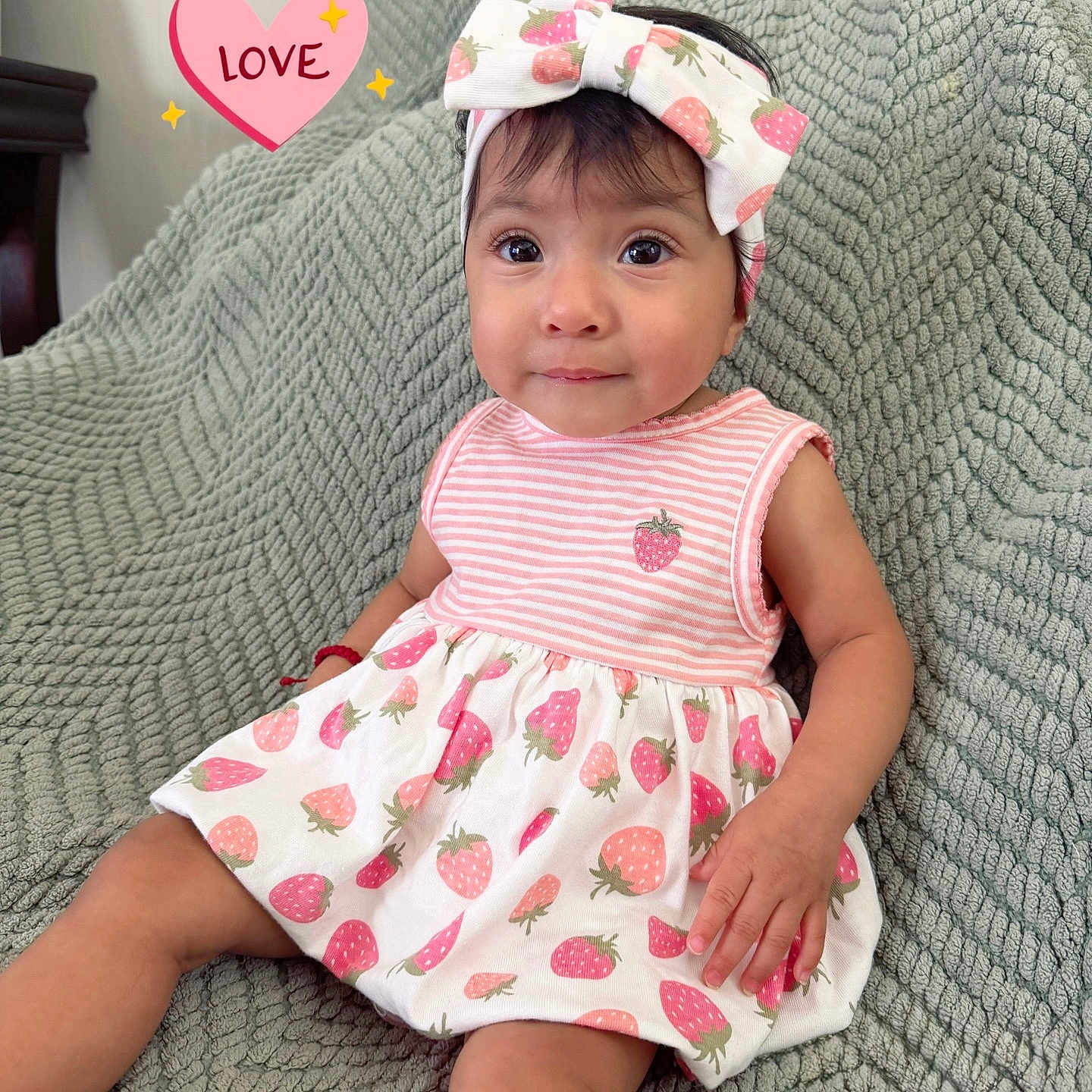 Arlette is registered to the contest to win money with this photo: baby, child, girl, dress, headband, bow, strawberry_pattern, pink, smiling, sitting, blanket, texture, love_heart, indoor, cute, portrait, happy, person, infant, apparel