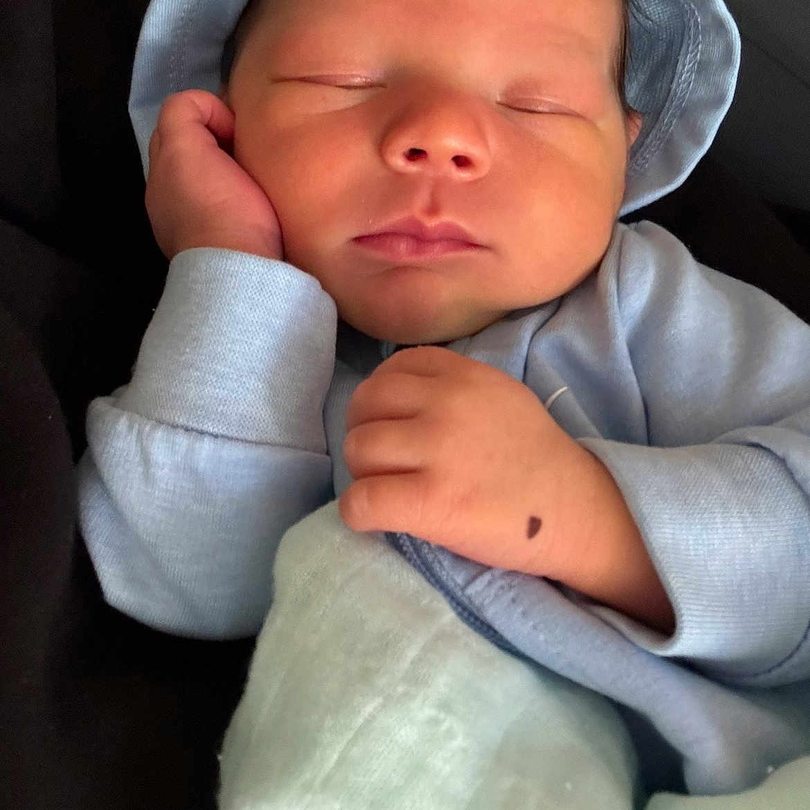 Khari is registered to the contest to win money with this photo: baby, newborn, sleeping, infant, hat, blue_clothing, blanket, hand, face, peaceful, cozy, cute, portrait, closeup, resting, soft, child, indoors, person, calm