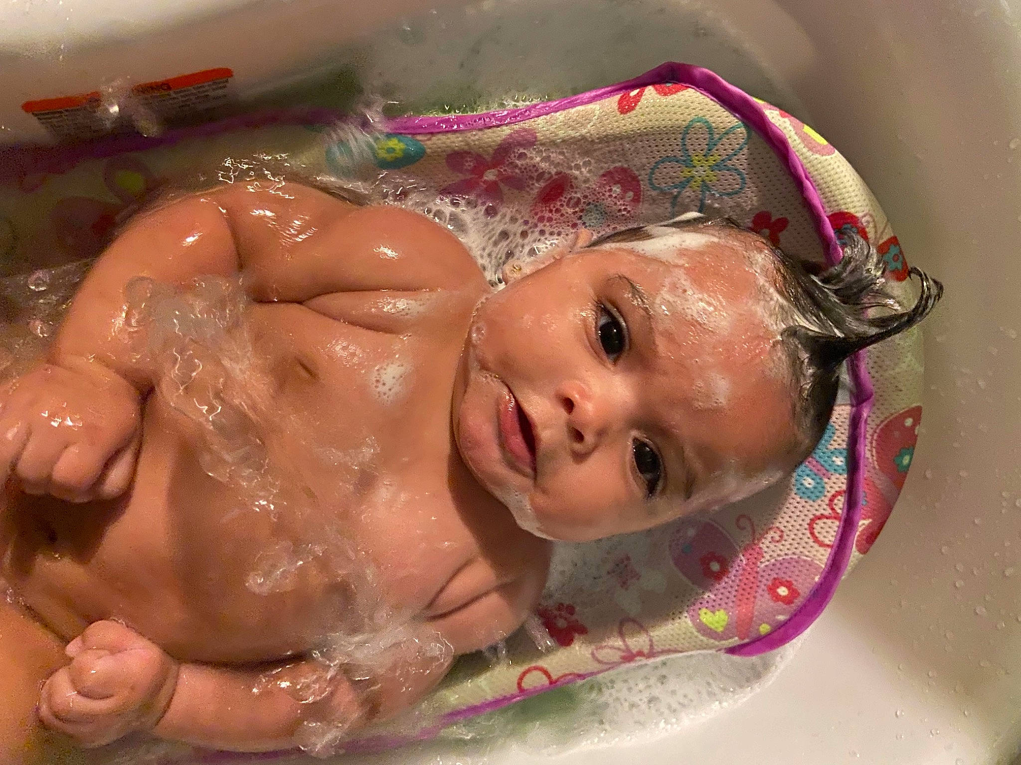 Addelyn is registered to the contest to win money with this photo: baby, bathing, cheek, chest, child, chin, eyebrow, facial_expression, foam, fun, happy, head, lip, mouth, nose, person, pink, skin, smile, toddler