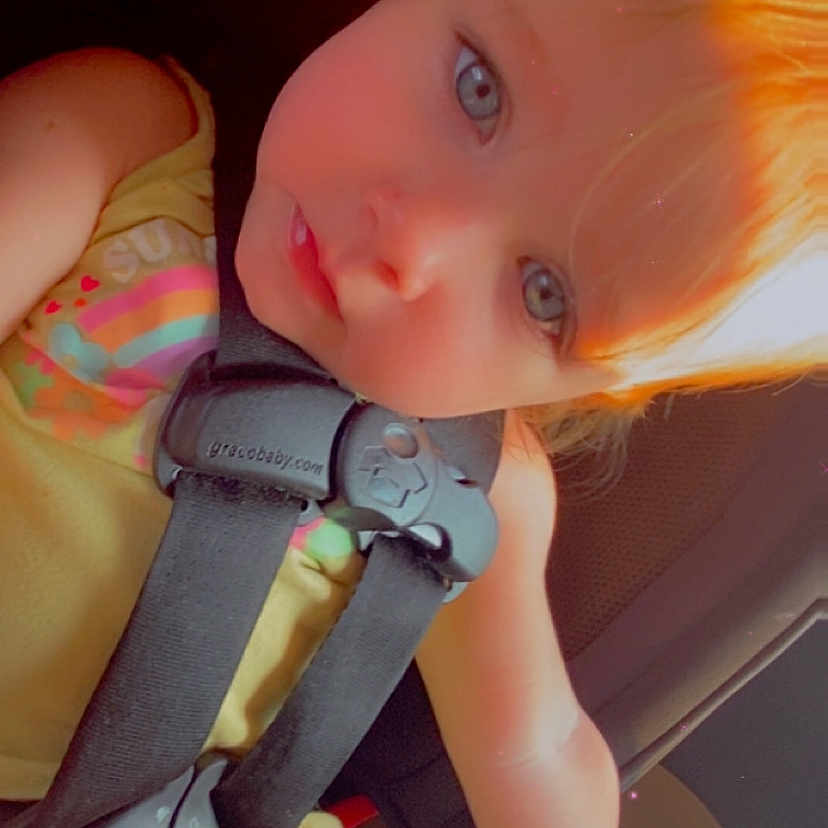 Arya joined the competition — help win amazing prizes! baby, blue_eyes, bottle, car_interior, car_seat, child, child_in_car, close_up, cute, drink_bottle, infant, light_hair, portrait, safety_harness, seat, seatbelt, sitting, toddler, yellow_clothing, young_child