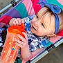 Arya is registered to the contest to win money with this photo: toddler, child, baby, headband, sippy_cup, stroller, colorful, outdoor, happy, smile, blue, orange, hand, face, clothing, toy, seat, person, cute, closeup