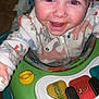 baby, child, closeup, clothing, colorful, cute, expression, face, fun, happy, indoors, infant, messy, pajamas, playtime, reaching, smiling, toy, walker, young