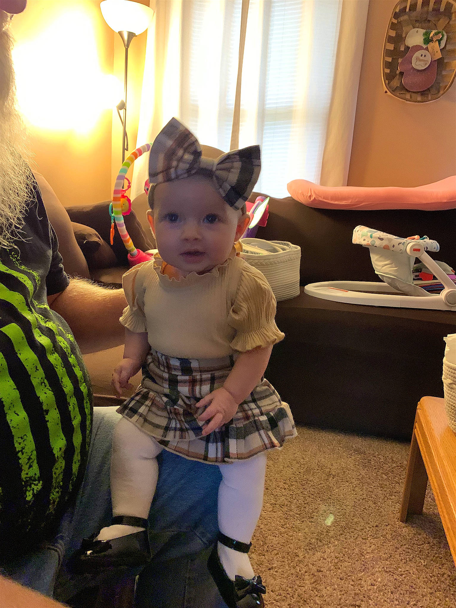 Madilyn is registered to the contest to win money with this photo: baby, child, comfort, couch, curtain, flooring, fun, fur, happy, lamp, living_room, person, picture_frame, pillow, plaid, room, sitting, stuffed_toy, toddler, toy