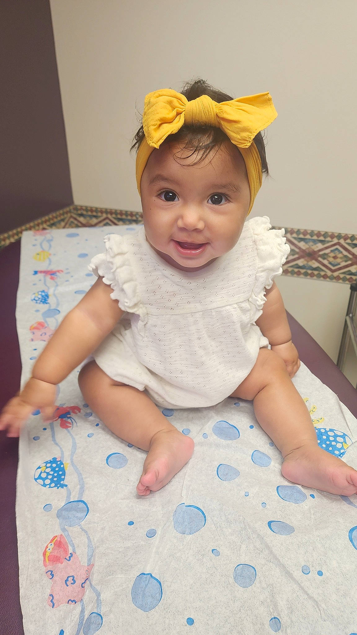 Mayela Jesslyn is registered to the contest to win money with this photo: baby, baby_toddler_clothing, cheek, child, dress, eye, floor, flooring, fun, happy, head, iris, linens, pattern, person, product, sitting, skin, sleeve, smile