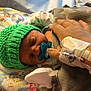 Theodore is registered to the contest to win money with this photo: newborn, baby, infant, pacifier, green_hat, blanket, hospital, iv_line, hand, sleeping, cute, child, medical, bed, soft, warm, tender, care, person, wrapped