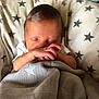 newborn, baby, sleeping, blanket, star_pattern, hands, face, cushion, bottle, infant, rest, cozy, indoors, soft_light, cute, peaceful, child, person, wrapped, toddler