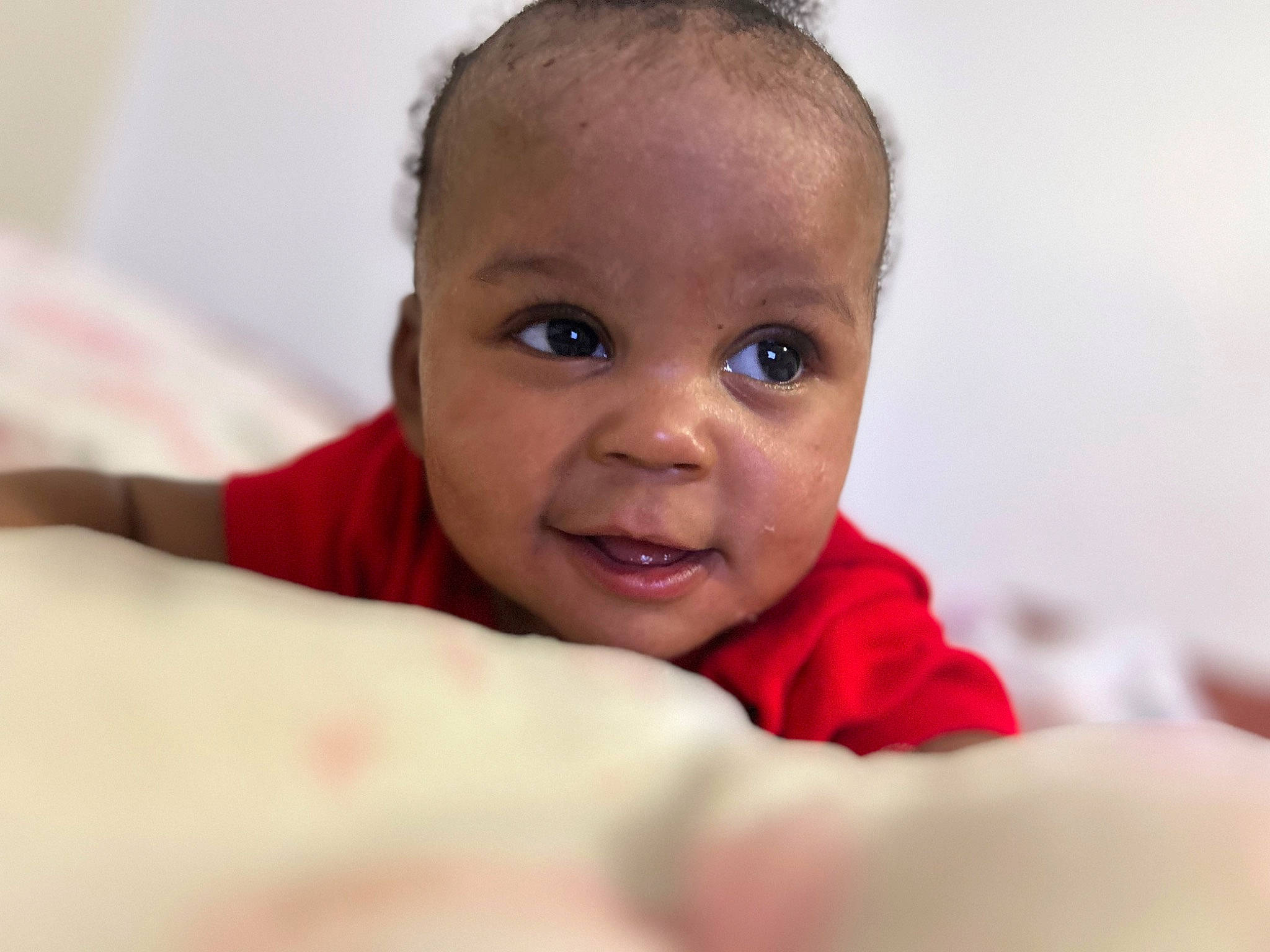 Nariyah is registered to the contest to win money with this photo: baby, cheek, child, comfort, ear, eyebrow, eyelash, gesture, happy, iris, linens, no_expression, nose, person, room, sitting, skin, smile, thumb, toddler