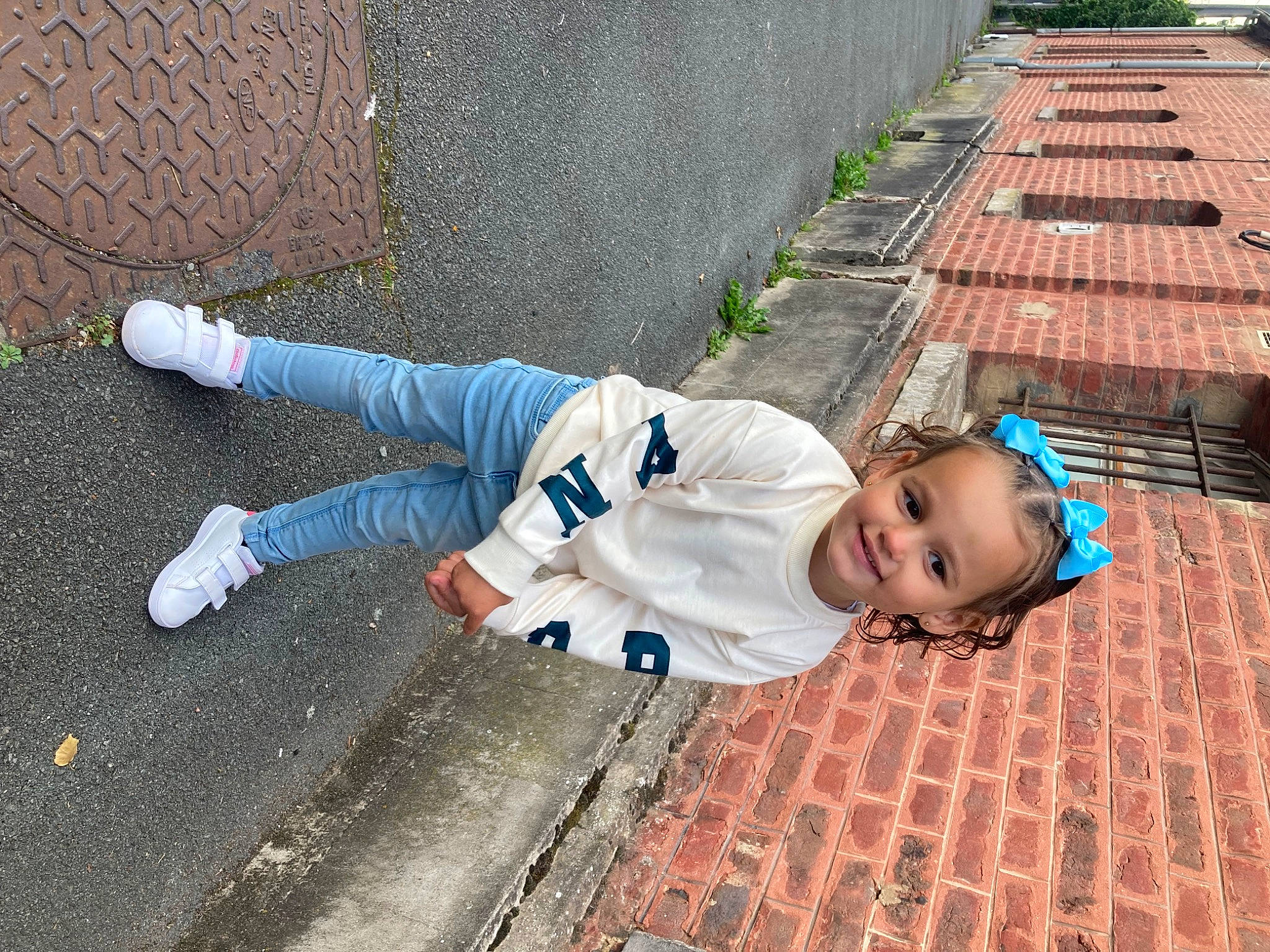 Naïla participe au concours pour gagner de l'argent avec cette photo : asphalt, carmine, child, city, concrete, flooring, fun, grass, joy, leisure, pattern, pedestrian, person, plant, road_surface, sidewalk, sitting, street, sunglasses, toddler
