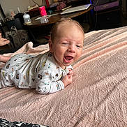 Ange a rejoint le concours — aidez-le/la à gagner de superbes lots ! baby, blanket, child, cozy, cushion, cute, expression, face, furniture, happy, home, indoor, infant, living_room, lying_down, onesie, person, smiling, table, television