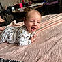baby, blanket, child, cozy, cushion, cute, expression, face, furniture, happy, home, indoor, infant, living_room, lying_down, onesie, person, smiling, table, television