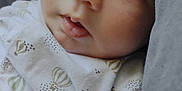 Arii participe au concours pour gagner de l'argent avec cette photo : baby, infant, close_up, face, blue_eyes, white_clothing, patterned_clothing, hot_air_balloon, cushion, gray, soft_texture, indoors, portrait, young_child, cute, calm, curious, skin, head, person
