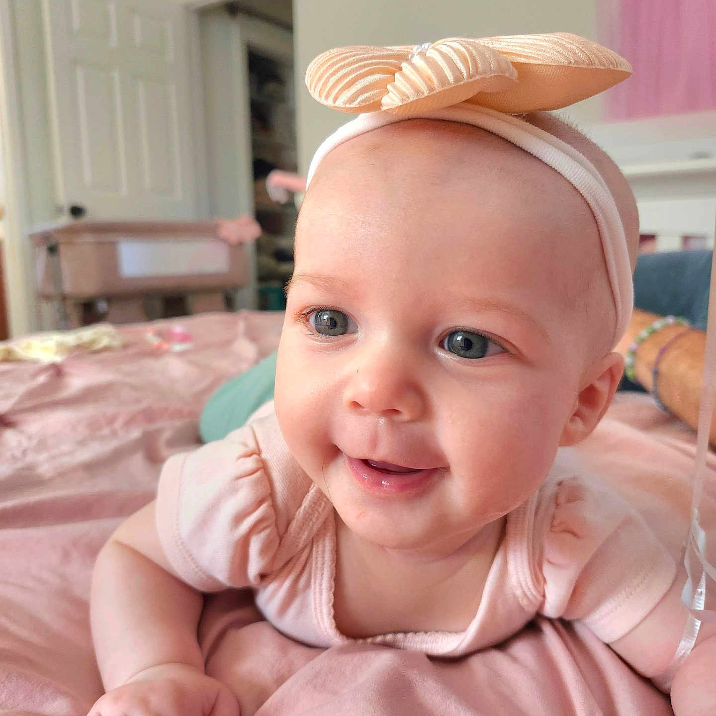 Antonella joined the competition — help win amazing prizes! baby, bed, blanket, blue_eyes, bow, child, cute, face, hand, happy, headband, indoor, infant, person, pink_clothing, portrait, skin, smile, soft_lighting, toddler