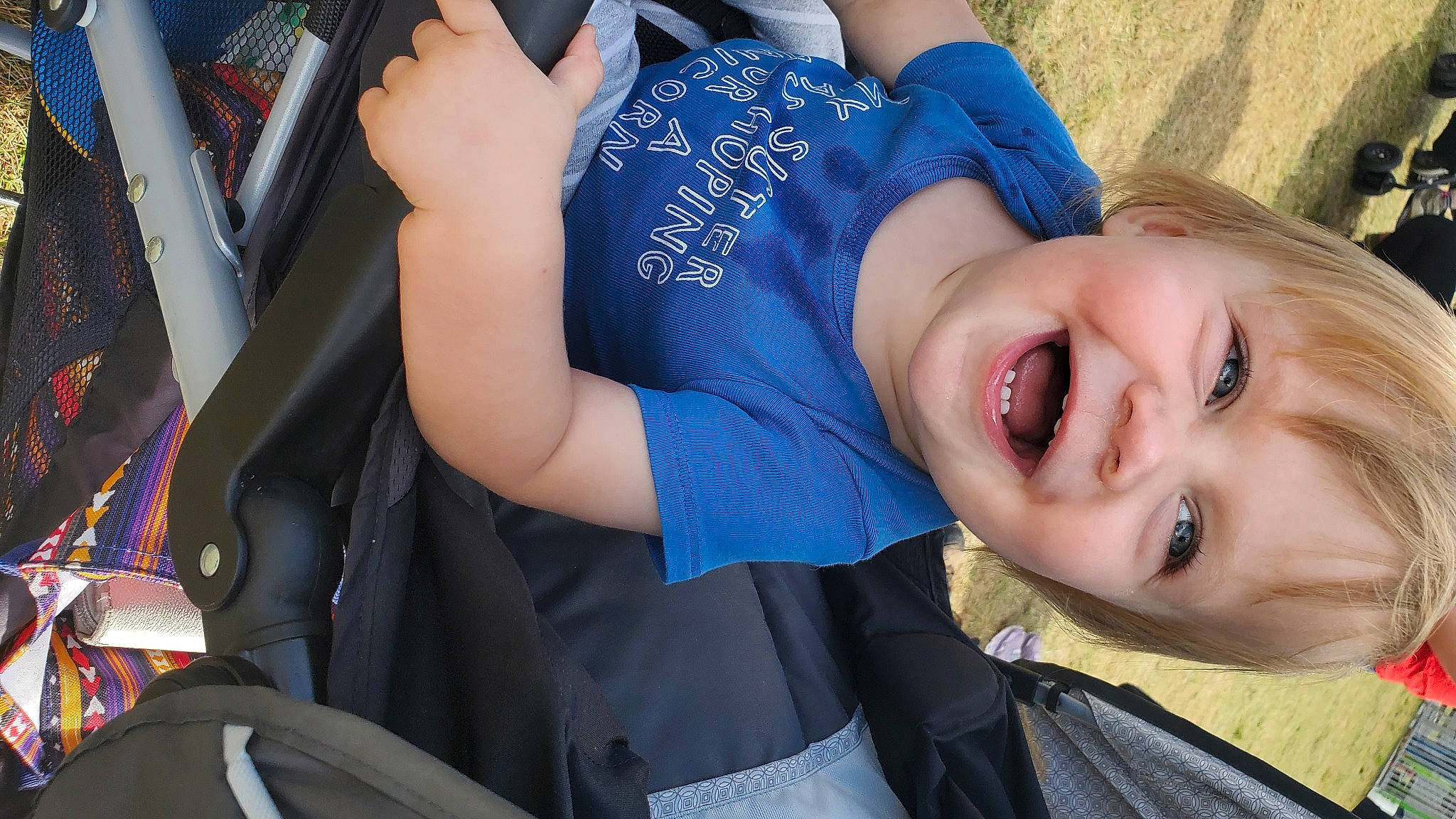 Dennis is registered to the contest to win money with this photo: automotive_design, child, cool, elbow, electric_blue, eye, fun, gesture, grass, happy, human_body, joy, leisure, person, plant, product, shoulder, smile, t_shirt, toddler