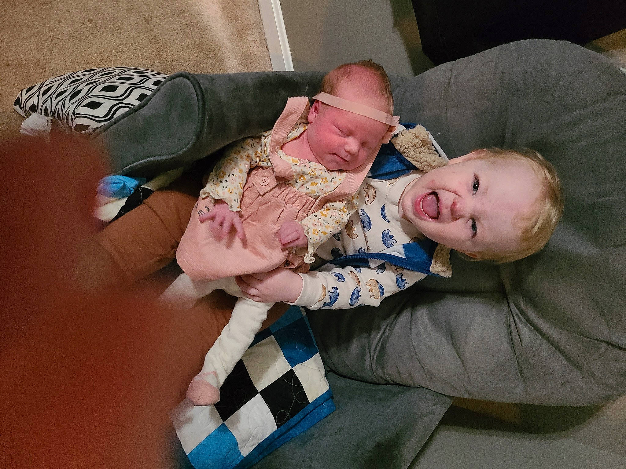 Kyler joined the competition — help win amazing prizes! baby, baby_products, baby_toddler_clothing, child, comfort, couch, foot, fun, headwear, lap, nail, nap, pattern, person, room, rubiks_cube, sitting, smile, sock, thumb