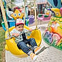 Mikaïl a rejoint le concours — aidez-le/la à gagner de superbes lots ! amusement_ride, cap, carnival, child, colorful, daytime, fun, grass, happy, jeans, metal_bar, outdoor, person, playground, safety_belt, smile, sneakers, sonic, swing, yellow_seat