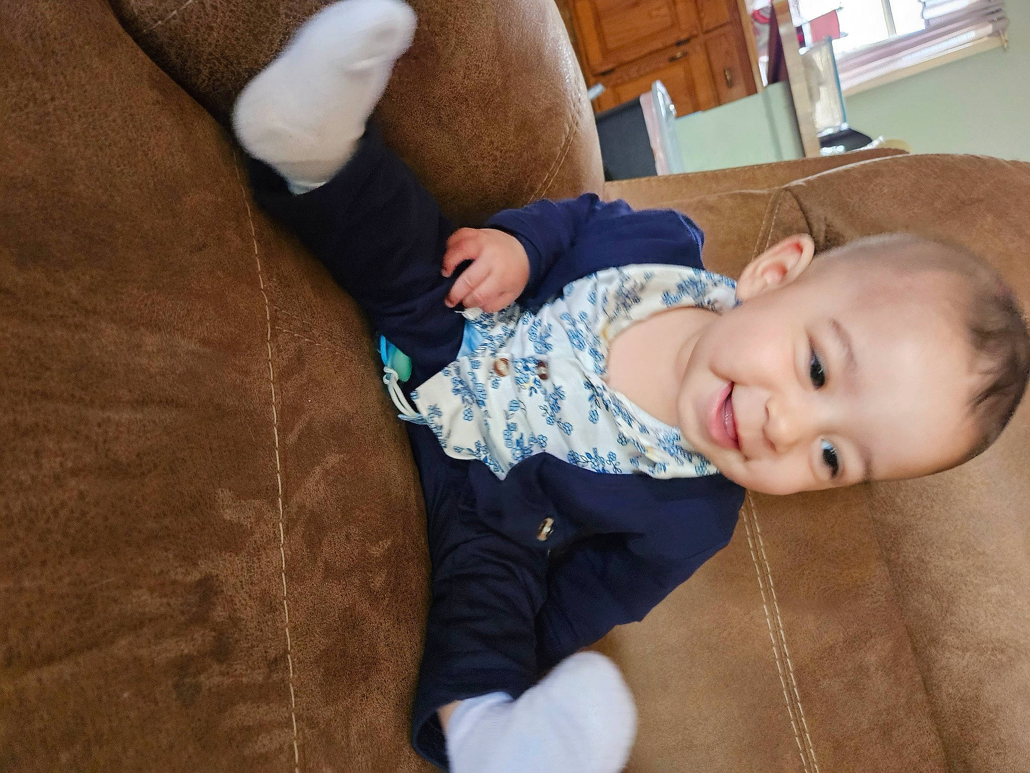 Bradley is registered to the contest to win money with this photo: baby, baby_toddler_clothing, cheek, child, comfort, couch, flooring, hardwood, joy, pattern, person, room, sitting, sleeve, smile, toddler, wood