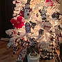 bow, cat, christmas_tree, cozy, decoration, festive, floor, fluffy_cat, holiday_decor, indoor, lights, ornaments, pet, plaid, poinsettia, seasonal, sitting, snowman, white_tree, wood_floor
