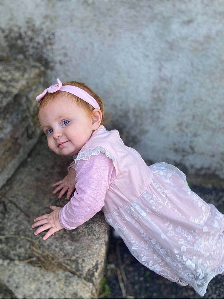 Iris participe au concours pour gagner de l'argent avec cette photo : baby, baby_toddler_clothing, blond, child, eye, face, flash_photography, grass, hair, happy, head, headgear, people_in_nature, person, pink, plant, skin, sleeve, smile, toddler