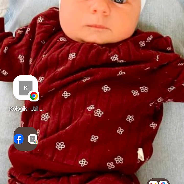 Cosie is registered to the contest to win money with this photo: app_icons, baby, blanket, bow, child, cushion, cute, eyes, face, headband, indoors, infant, lying_down, maroon_clothing, mobile_screen, patterned_clothing, person, phone_interface, status_bar, wood_floor