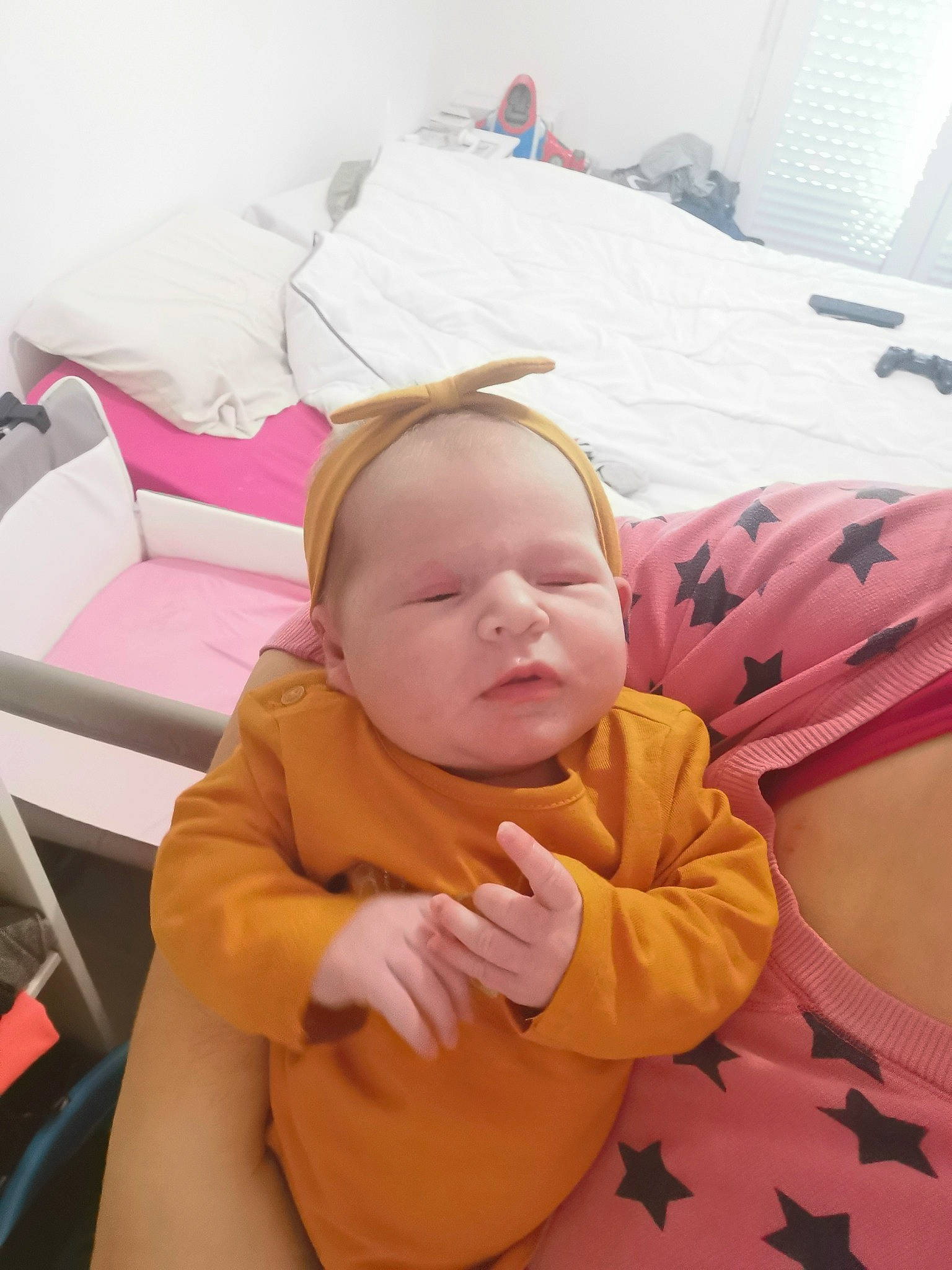 Rosalie a rejoint le concours — aidez-le/la à gagner de superbes lots ! baby, baby_products, baby_sleeping, baby_toddler_clothing, bedding, bedtime, cheek, child, comfort, couch, flooring, happy, linens, nap, person, pink, room, sitting, studio_couch, textile