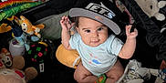 Jeannette joined the competition — help win amazing prizes! baby, child, playpen, toys, stuffed_animals, hat, cap, drool, indoor, bookshelf, books, colorful, cute, curious, sitting, person, infant, clothing, baby_toys, soft_toys