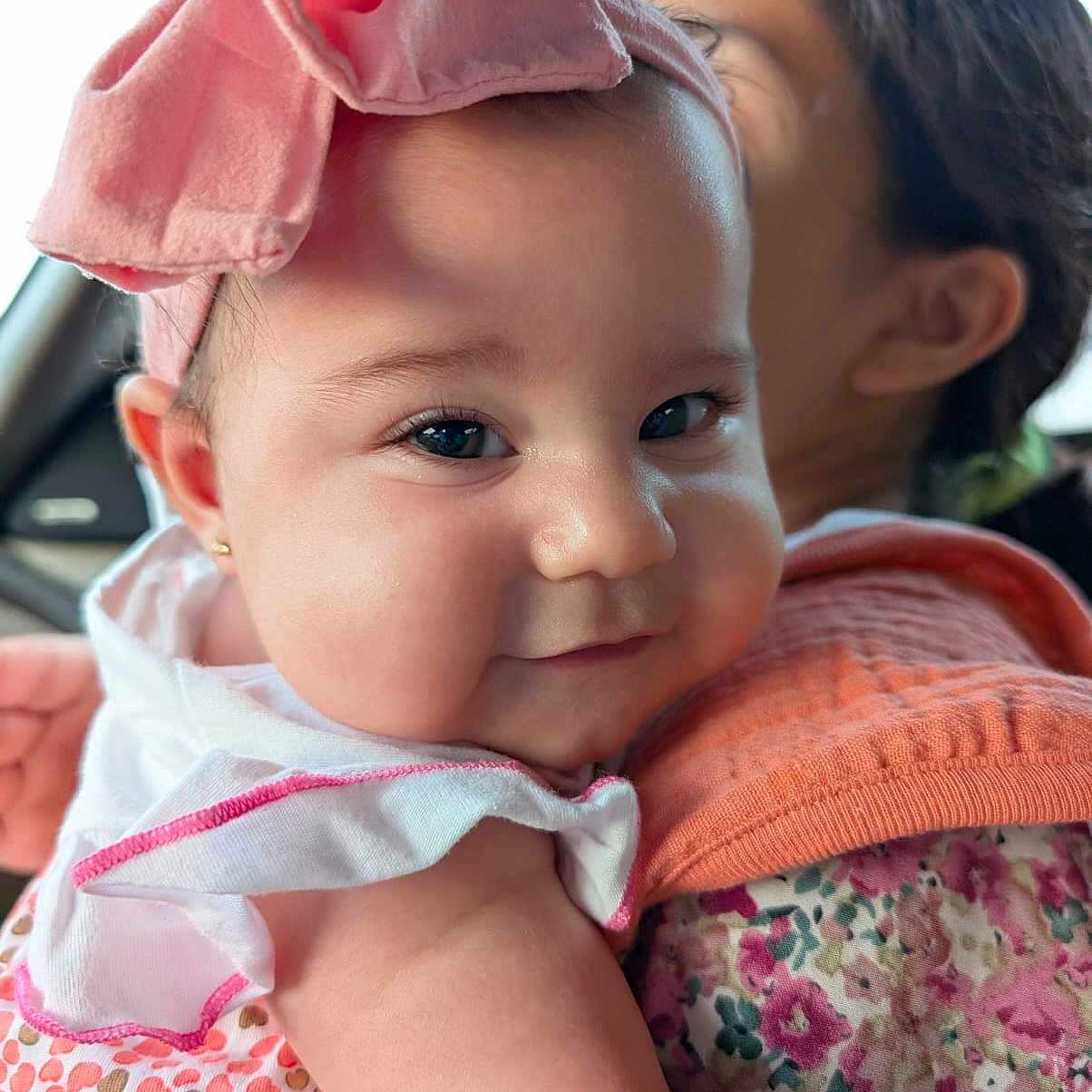 Jeannette joined the competition — help win amazing prizes! arm, baby, car_interior, cheeks, child, closeup, clothing, cute, fabric, face, floral_pattern, headband, holding, indoor, person, pink, portrait, skin, smile, woman