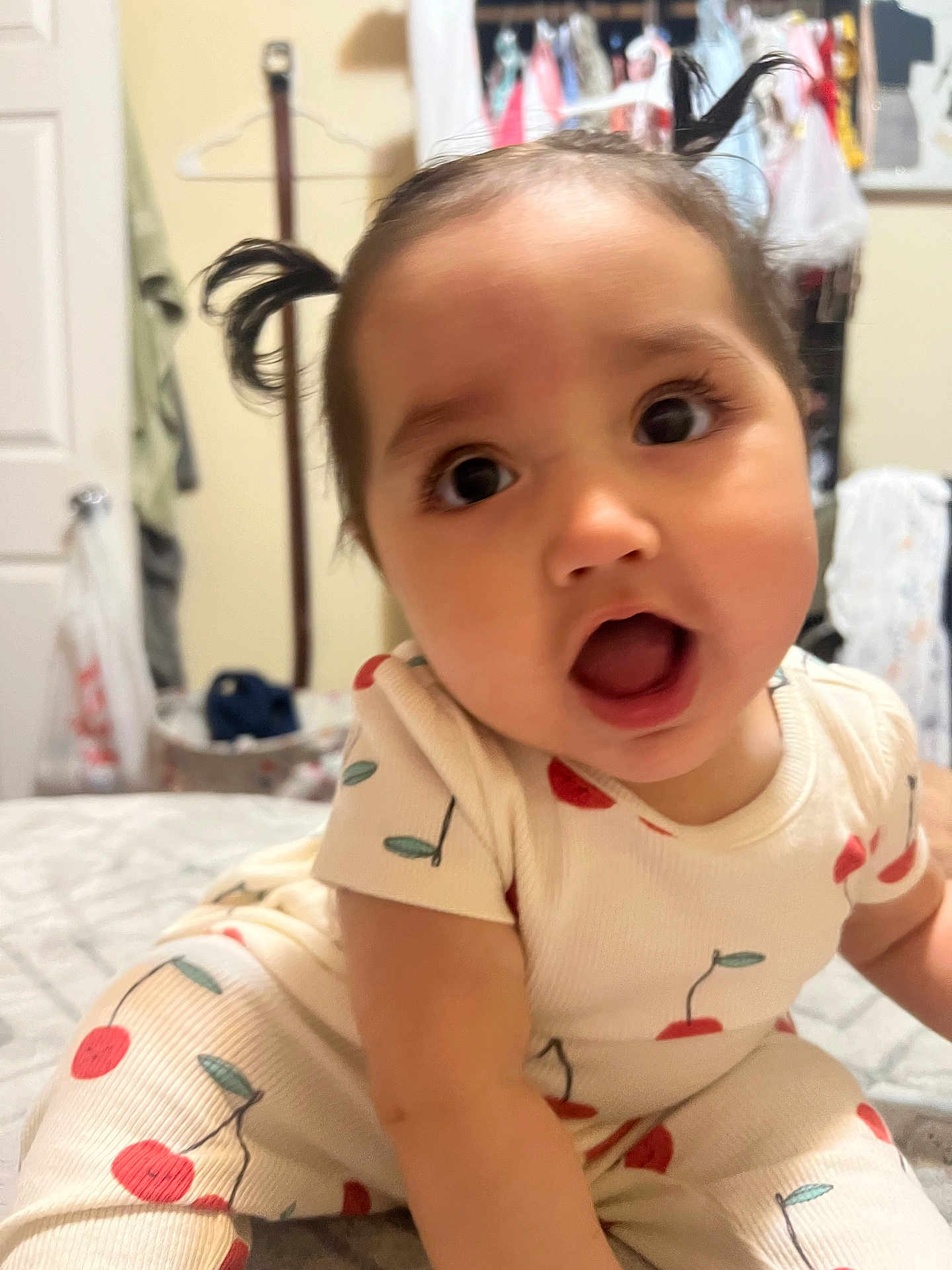 Elizabeth Hope joined the competition — help win amazing prizes! baby, child, face, pigtails, expression, indoor, clothing, pattern, cherry, cute, person, bed, room, furniture, curious, infant, portrait, young, skin, sitting