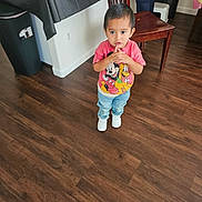 Ezekiel joined the competition — help win amazing prizes! toddler, child, indoor, floor, wooden_floor, jeans, tshirt, mickey_mouse, pluto, white_shoes, chair, table, black_tablecloth, person, standing, looking_up, hands_together, expression, adult, home