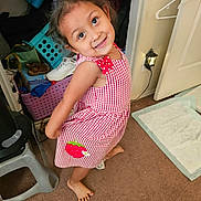 Leilani joined the competition — help win amazing prizes! child, girl, smiling, red_dress, checkered_pattern, barefoot, indoor, carpet, clutter, shoe, hanger, lamp, closet, toy, person, cute, happy, posing, room, playful