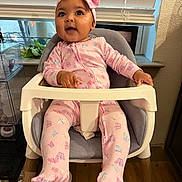 Paloma joined the competition — help win amazing prizes! baby, child, infant, high_chair, pink_clothing, headband, butterfly_pattern, smiling, happy, indoor, window, blinds, plant, wooden_floor, modern_furniture, cute, portrait, seated, person, home