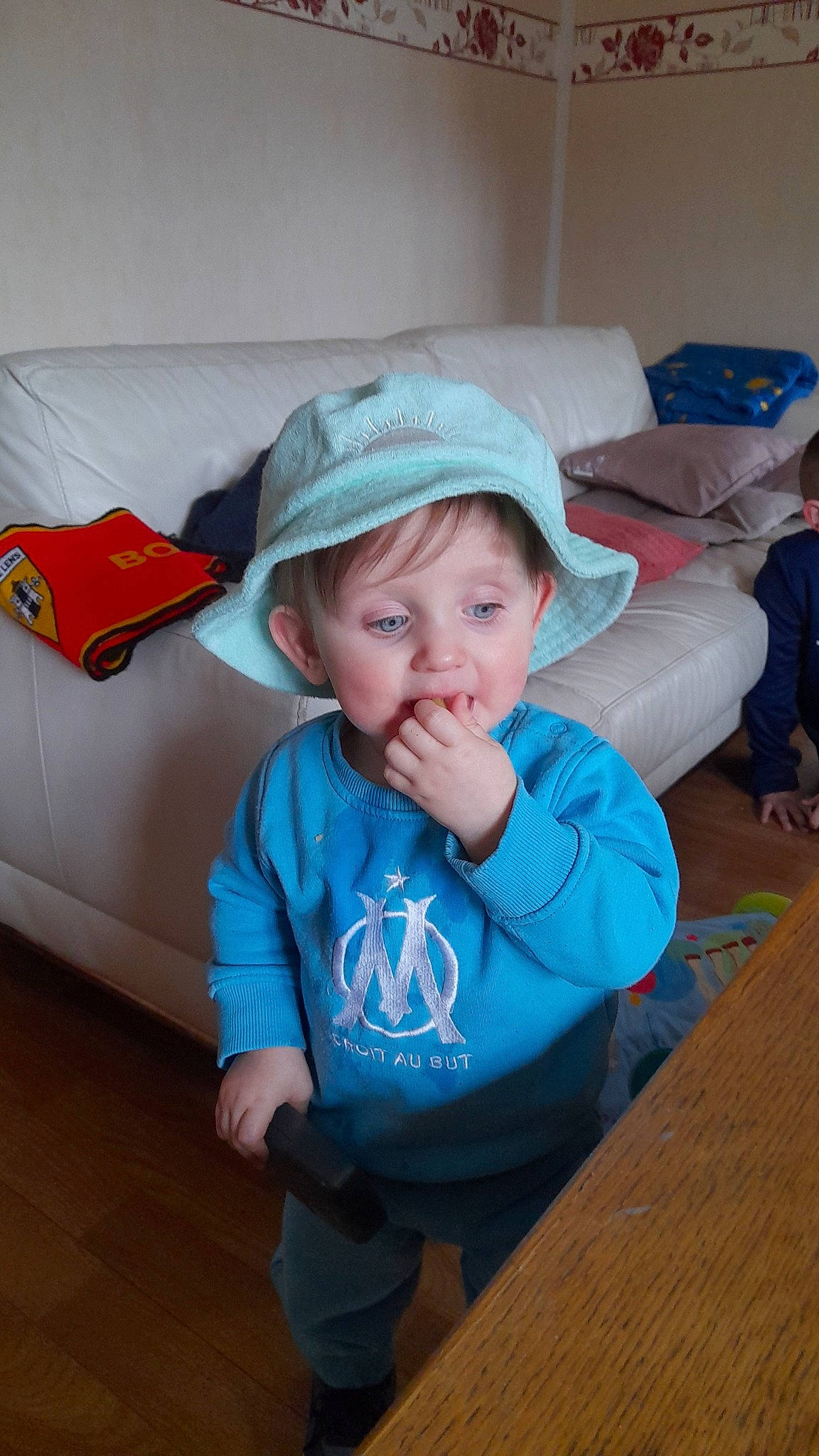 Maylan a rejoint le concours — aidez-le/la à gagner de superbes lots ! baby, baby_toddler_clothing, baseball_cap, cap, child, comfort, electric_blue, fashion_accessory, flooring, fun, happy, hardwood, hat, headwear, person, room, sitting, skin, t_shirt, toddler