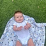 baby, infant, blanket, sheep_pattern, grass, outdoor, smile, playful, toddler, clothing, cute, lying_down, child, nature, young_child, happy, casual, portrait, baby_girl, baby_boy