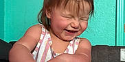 Emelia is registered to the contest to win money with this photo: toddler, child, laughing, happy, face, hair, arm, hands, striped_clothing, tank_top, indoor, wall, turquoise, texture, playpen, infant, person, smile, joy, candid