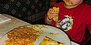Emelia joined the competition — help win amazing prizes! toddler, child, messy_face, food, rice, beans, quesadilla, plate, red_shirt, cartoon_character, restaurant, table, eating, meal, indoor, high_chair, window, tile_wall, yellow_pole, napkin